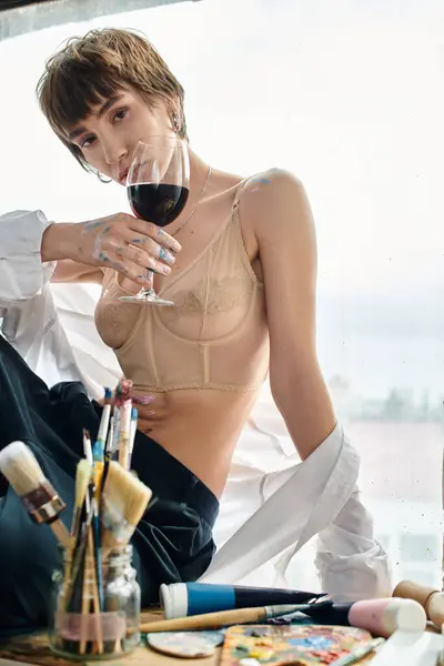 Woman relaxes on window sill, sipping wine. — Stock Photo
