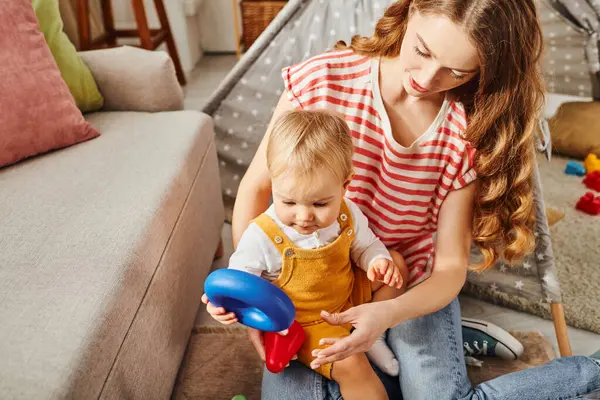 A young mother enjoying tender moments with her toddler daughter while playing on the floor. — Stock Photo