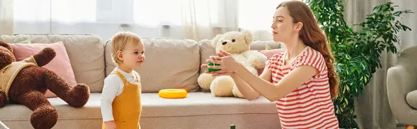 Une jeune mère s'engage avec son tout-petit dans une séance de jeu réconfortante à la maison. — Photo de stock