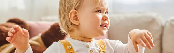 Kleinkind-Mädchen in gelbem Kleid erlebt Freude in gemütlicher Umgebung. — Stockfoto