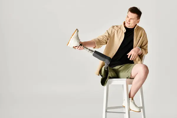 A handsome man with a prosthetic leg sitting on a stool. — Stock Photo
