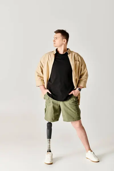 Um homem bonito com uma perna protética posa em uma postura ativa e graciosa. — Fotografia de Stock
