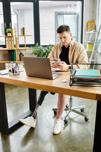 Handsome businessman with prosthetic leg working on laptop at desk. — Stock Photo