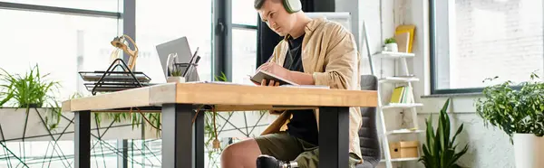 A handsome businessman with a prosthetic leg using a laptop at a desk. — Stock Photo