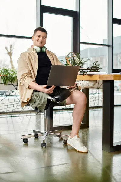 Handsome businessman with prosthetic leg working on laptop in modern chair. — Stock Photo