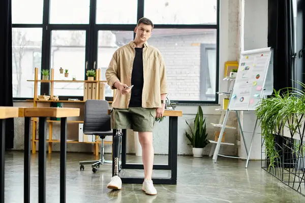 Um homem de negócios bonito com uma perna protética de pé confiantemente na frente de uma mesa em um escritório. — Fotografia de Stock