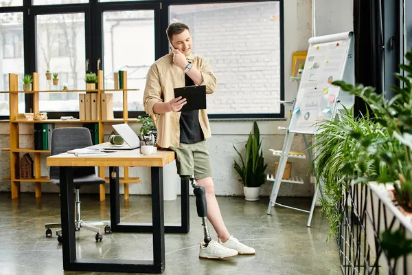 Handsome businessman with prosthetic leg, holding tablet in office. — Stock Photo