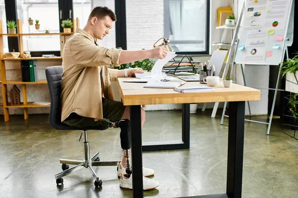 Um belo homem de negócios com uma perna protética trabalhando diligentemente em sua mesa. — Fotografia de Stock