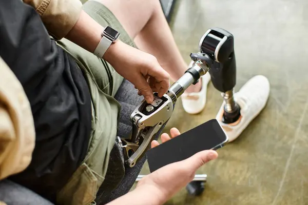 Ein Geschäftsmann mit Beinprothese sitzt und checkt sein Handy. — Stockfoto