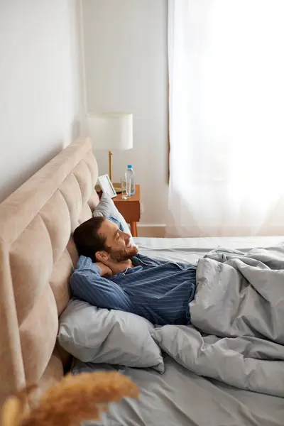 Um homem descansa pacificamente na cama em casa. — Fotografia de Stock