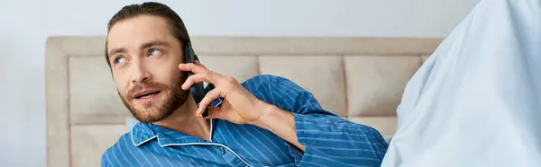 Чоловік у піжамі спілкується на мобільному телефоні. — стокове фото