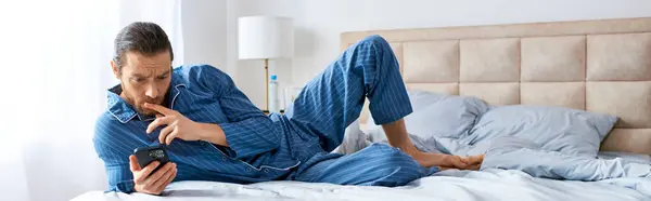Un homme allongé sur un lit, engagé dans un appel téléphonique. — Photo de stock