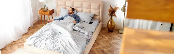 Ein Mann liegt friedlich auf seinem Bett in einem gemütlichen Schlafzimmer. — Stockfoto