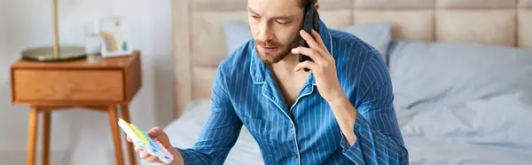 Man multitasking with cell phone and pill case, morning routine at home. — Stock Photo
