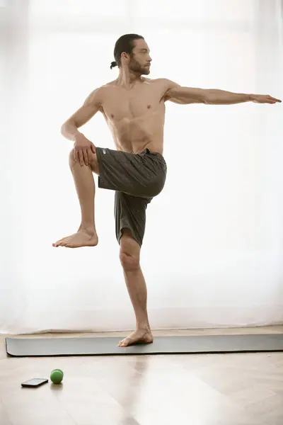 Hombre guapo practica yoga en una alfombra en casa. - foto de stock