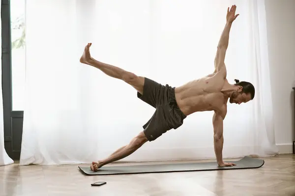 Handsome man at home, practicing yoga on a mat. — Stock Photo