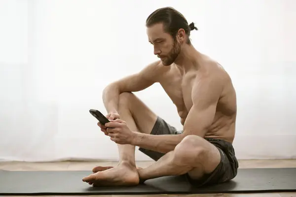 Uomo che fa yoga, concentrato sullo schermo del telefono. — Foto stock