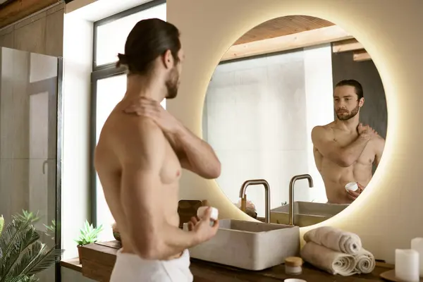 Bonito homem skincare rotina no espelho do banheiro. — Fotografia de Stock