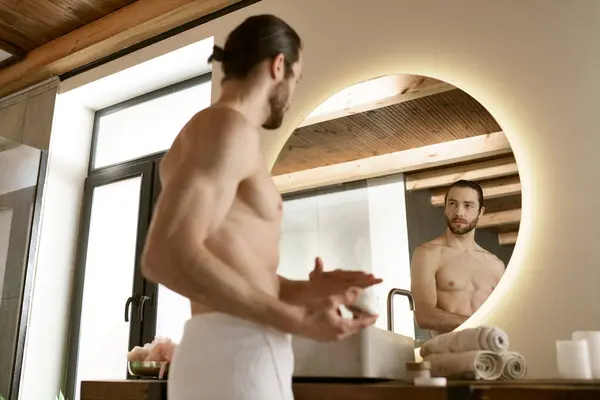 Bel homme dans la salle de bain, s'engager dans la routine de soins de la peau du matin et toilettage devant le miroir. — Photo de stock