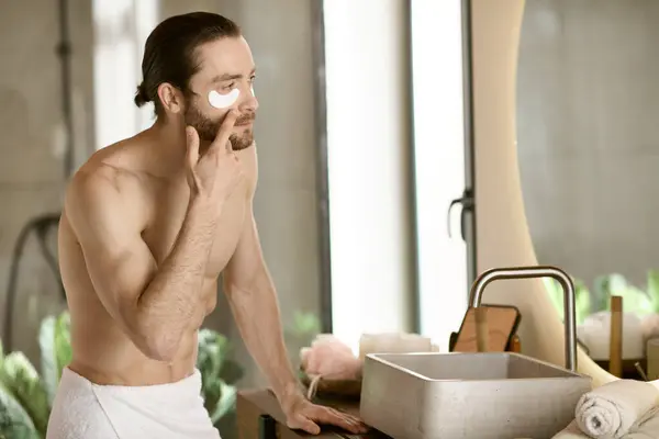 Homem aplicando manchas admirando sua rotina matinal de cuidados com a pele no espelho. — Fotografia de Stock