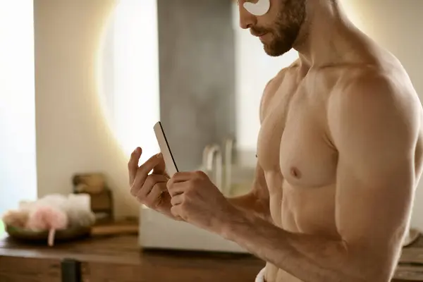 Shirtless man holds nail file, surrounded by grooming products. — Stock Photo