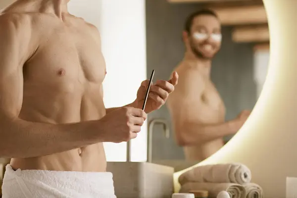 A man using nail file in front of a mirror during his morning routine. — Stock Photo