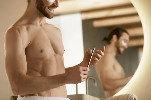 A shirtless man using nail file in front of a mirror at home. — Stock Photo