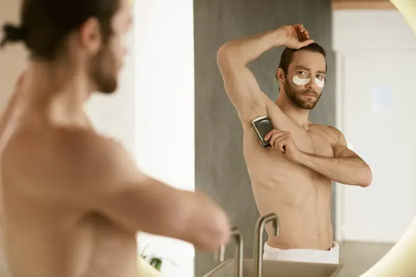 Uomo senza camicia con deodorante a casa. — Foto stock