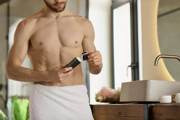 Красивий чоловік в рушнику використовує дезодорант. — стокове фото