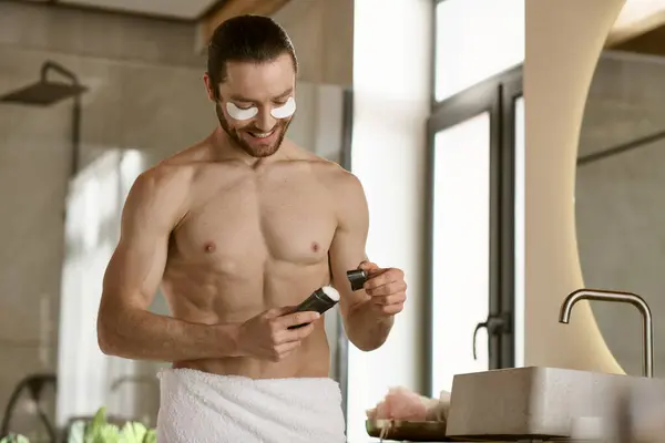 Un homme dans une serviette en utilisant du déodorant dans une salle de bain. — Photo de stock