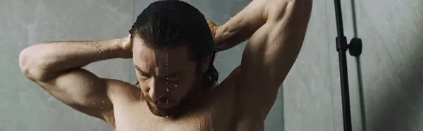 Un hombre sin camisa tomando una ducha. - foto de stock