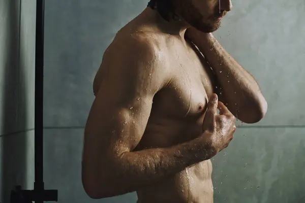 Hemdloser Mann steht vor der Dusche, Teil seiner morgendlichen Hautpflege-Routine. — Stockfoto