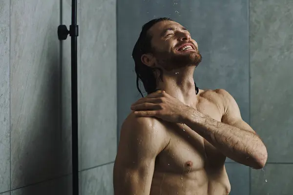 Um homem bonito em pé na frente de um chuveiro, se preparando para sua rotina matinal. — Fotografia de Stock