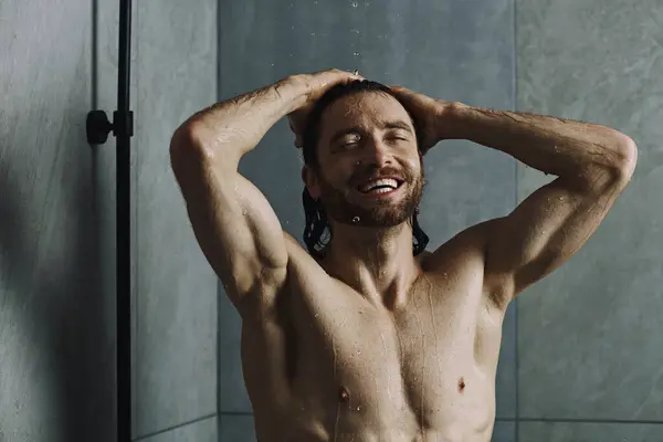 Uomo senza maglietta a casa, eseguendo routine mattutina, in piedi di fronte a una doccia. — Foto stock