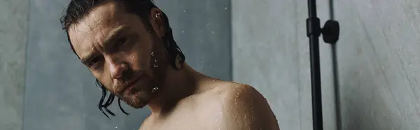 A shirtless man standing in front of a shower, preparing for the day. — Stock Photo