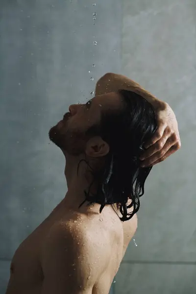 Ein gutaussehender Mann, der seine morgendliche Routine ausübt und duscht. — Stockfoto