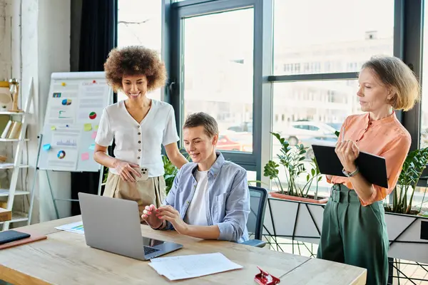 Diverse group of businesswomen using laptop at table in office. — Stock Photo
