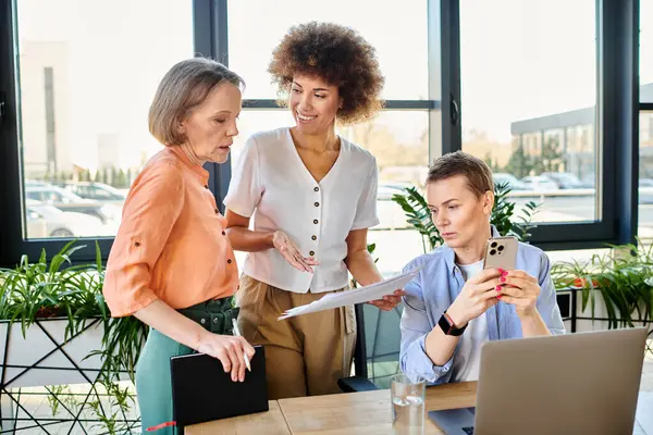 Diverse group of businesswomen engage with a laptop screen in an office setting. — Stock Photo