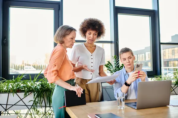 Profissionais do sexo feminino se reúnem em torno de um laptop para uma sessão de trabalho produtivo. — Fotografia de Stock