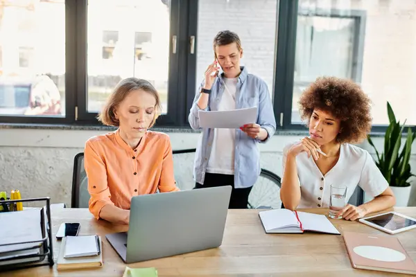 A diverse group of hardworking businesswomen collaborating around a wooden table. — Stock Photo