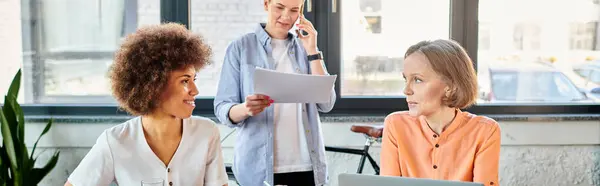 A diverse group of hardworking businesswomen sit around a table, engaged in a discussion. — Stock Photo