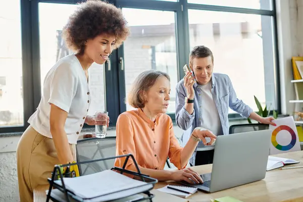 Diverse group of female businesswomen, including LGBT women, collaborating around a laptop in an office setting. — Stock Photo