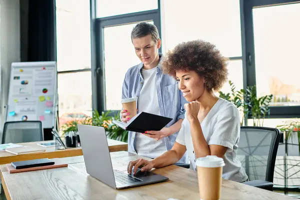 Diverse colleagues engaged in collaborative work on a laptop. — Stock Photo