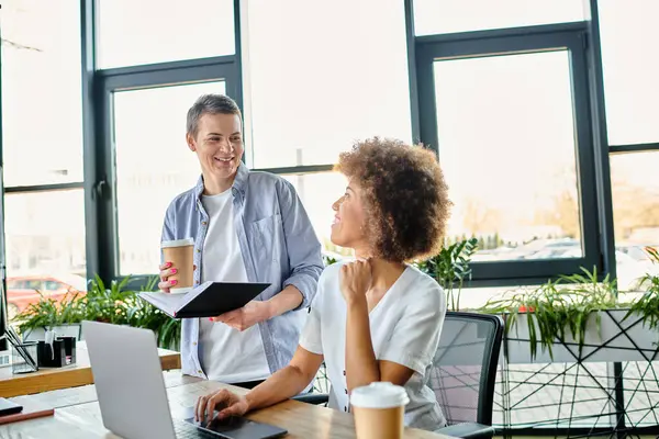 Diverse women deeply engrossed in work at a laptop on a table. — Stock Photo
