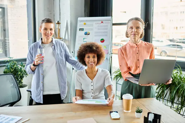 Hardworking businesswomen collaborate at a wooden table in an office setting. — Stock Photo