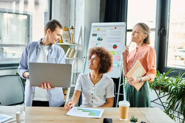 Diverse group of female professionals gathered around a table with a laptop in a modern office. — Stock Photo