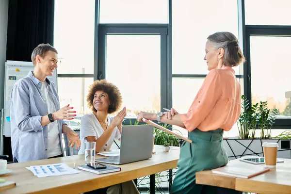 Diverse group of hard-working businesswomen gather around a table with a laptop in a coworking space. — Stock Photo