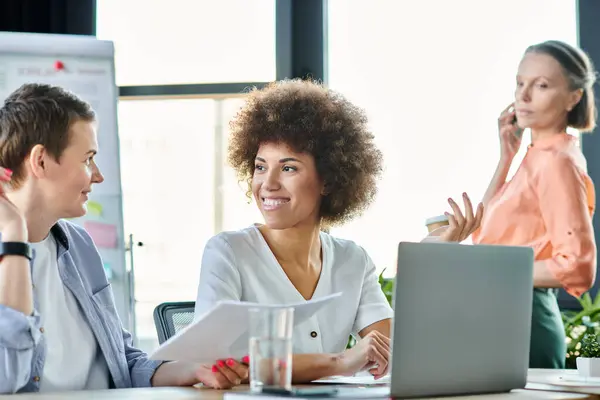 Un groupe de femmes d'affaires travailleuses et diversifiées engagées dans une discussion animée autour d'une table dans un espace de coworking. — Photo de stock