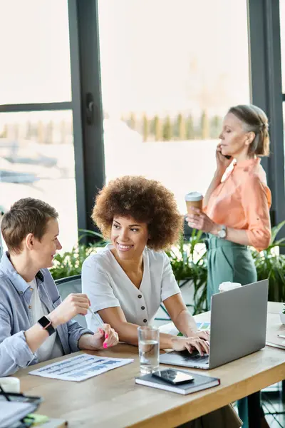 A group of hard-working, diverse, and pretty businesswomen discussing and working together at a wooden table in an office setting. — Stock Photo