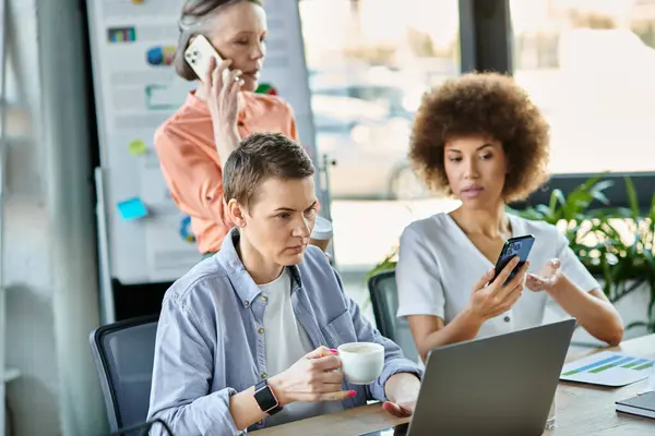 Diverse businesswomen immersed in digital work at a table — Stock Photo